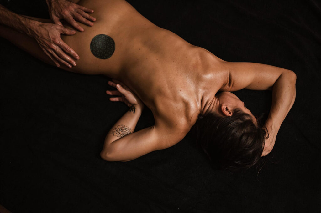 mulher deitada de costas nua sendo massageada