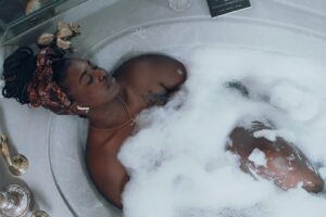 mulher relaxando em uma banheira enquanto escuta música