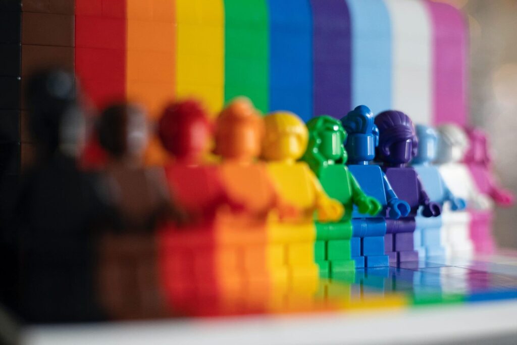 Foto de bonecos enfileirados e cada um tem uma cor da bandeira LGBTQIA+